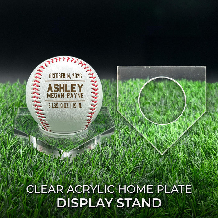 Personalized engraved baseball birth announcement displayed upright on a clear acrylic home plate stand.