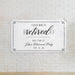 Retirement banner mounted on a white brick wall featuring a personalized retirement party welcome message and event date.