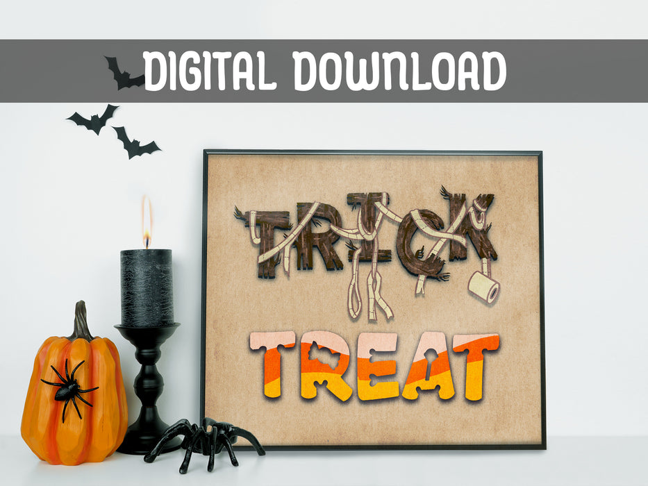 DIGITAL DOWNLOAD: Halloween Trick or treat typography art print in black frame in front of white wall surrounded by halloween decor such as spiders, bats, pumpkins, and a candle.