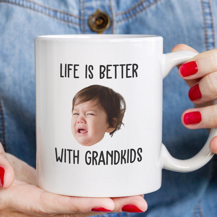 Custom grandparents photo mug held in hand with a child’s face printed on the design.