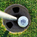 Top view of a personalized retirement golf ball resting in a golf cup. Features the custom "Retired And Loves It" design and personalized name.