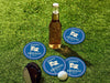 Custom round pulpboard coasters are shown sitting grass with a beer bottle, golf club, and golf ball surrounding them. The custom coasters feature design printed with blue background, pink circular border, and a beige illustrated golf flag.