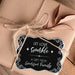 Close-up of a cardstock “Let Love Sparkle” wedding gift tag tied onto blush fabric wrapping with twine. The personalized foil tag features decorative flourishes and custom names.