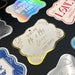 Close-up display of personalized “Mr. & Mrs.” wedding gift tags in multiple foil finishes and cardstock colors. The elegant design features custom couple names and sender personalization for weddings and bridal showers.