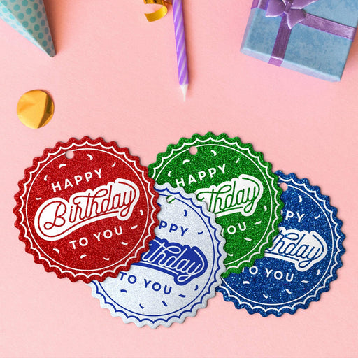 Four birthday round tags in glitter blue, glitter red, glitter green, and glitter white.