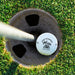 Top view of a personalized retirement golf ball resting in a golf cup. Features the Happy Retirement Palm Trees design and custom name.