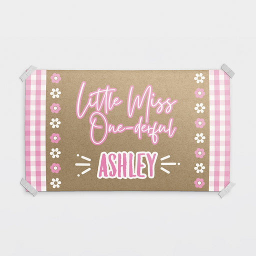 Personalized Little Miss ONE-derful birthday banner printed on brown butcher paper with pink gingham accents, floral details, and custom name personalization.