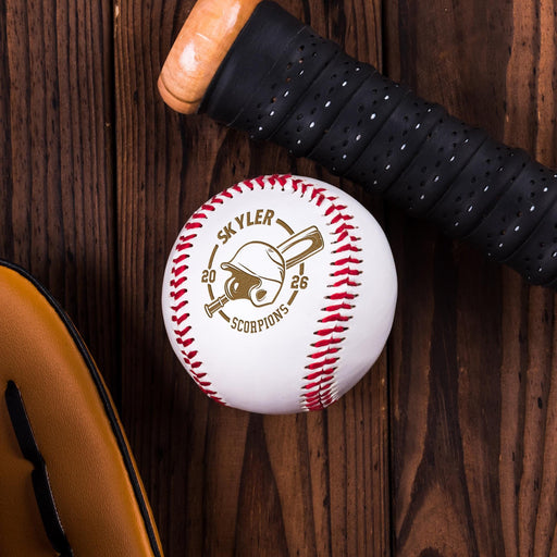 A personalized baseball, a helmet, and a black glove are arranged on a wooden surface.