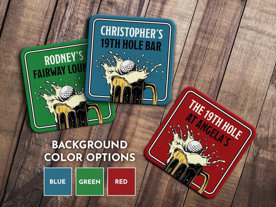 Custom square pulpboard coasters are shown sitting on a wooden table. Three custom coasters feature a 19th hole bar design with an illustration of a golf ball splashing into a beer mug and feature all available background color options: Blue, Green, Red