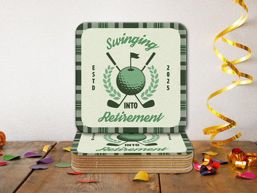 Custom square pulpboard coasters are shown on a wooden surface with confetti surrounding them. The coaster features design with illustrated golf ball, club, and flag on top with wreath surrounding it, argyle background pattern, and custom text.