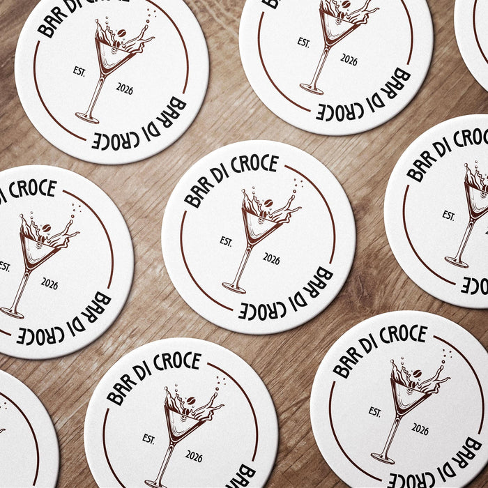 Several personalized espresso martini coasters spread across a tabletop, each featuring the custom bar name, espresso martini glass illustration, and established year.