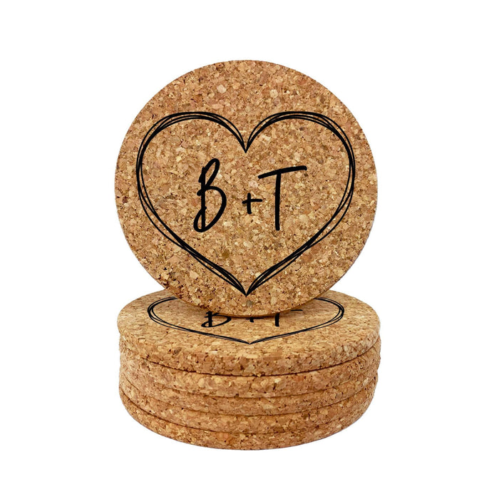 Stack of round cork coasters featuring a large hand-drawn heart design with personalized initials on a white background.