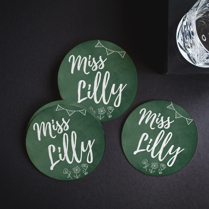 Multiple personalized chalkboard coasters arranged on a dark background. Showcases design variation and visual contrast.