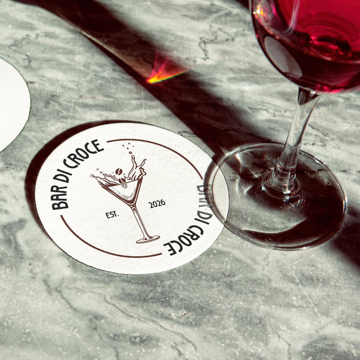 Personalized espresso martini coaster placed beside cocktail glasses on a marble bar surface, featuring the custom bar name, espresso martini illustration, and established year.