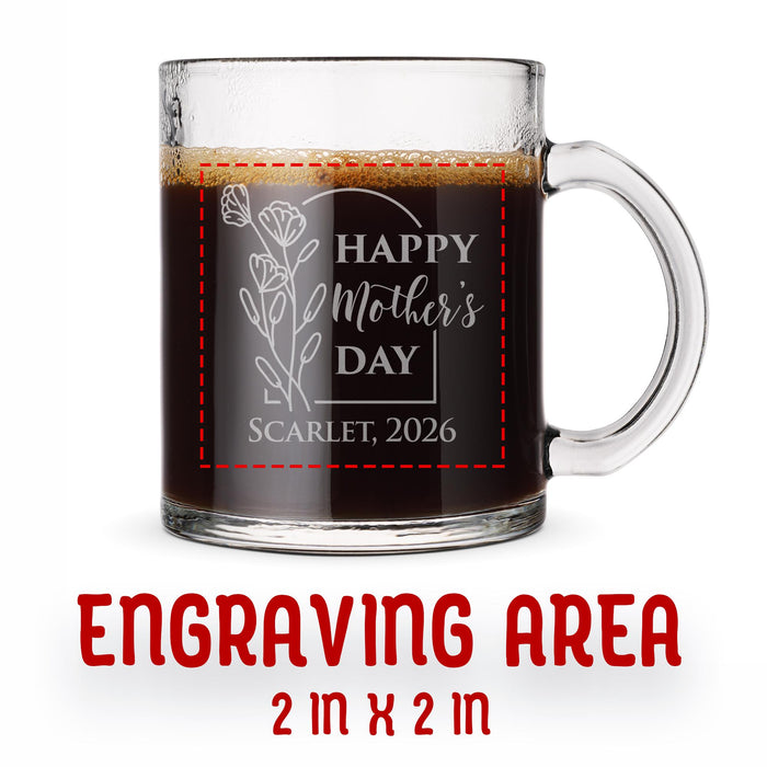 A glass mug with an engraved design on it. The mug is filled with tea, and there is text under the mug that reads "Engraving Area is 2 in x 2 in”