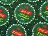 Custom round pulpboard coasters are shown spread out across a dark green surface covered in red and gold star confetti. The coasters read Reggie Masters Retirement 2026. These feature a red, green, and yellow Masters-themed retirement party design with the retiree’s name and retirement date.
