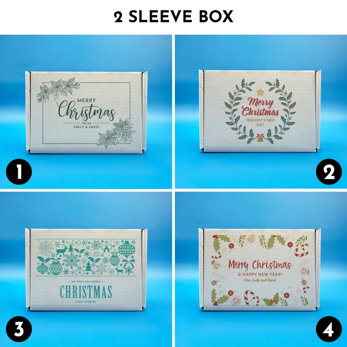 Two sleeve Christmas golf ball gift boxes shown in four printed designs, including botanical, wreath, blue sweater-style, and festive holiday illustration designs.