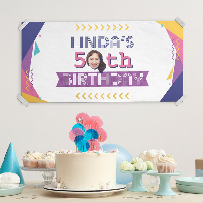 Close-up of the retro birthday banner displayed at a celebration with cake and party decorations.
