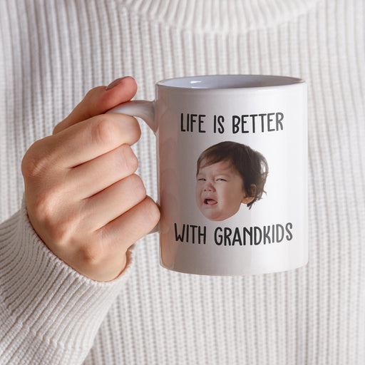 Personalized grandkids photo mug held in hand with “Life Is Better With Grandkids” design.