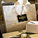 Wedding gift bags and favor boxes displayed with personalized “Your Biggest Fans” gold foil wedding gift tags. Styled for elegant wedding receptions, showers, and celebration gifting.
