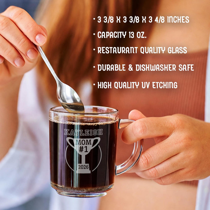 A person is holding a glass mug with a message engraved on it. The image is accompanied by a text overlay that reads • 3 3/8 x 3 3/8 x 3 4/8 inches • Capacity 13 oz. • restaurant quality glass • durable & dishwasher safe • high quality uv etching