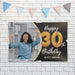 Personalized black and gold birthday banner displayed on a white brick wall with decorative party bunting.