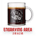 A glass mug with an engraved design on it. The mug is filled with tea, and there is text under the mug that reads "Engraving Area is 2 in x 2 in”