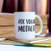 “Ask Your Mother” mug placed beside a notebook and pen in a soft desk setting. The image highlights practical everyday use and gift versatility.