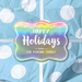 A rainbow gift tag with the text "Happy Holidays" against a background of crumpled blue paper with white polka dots.