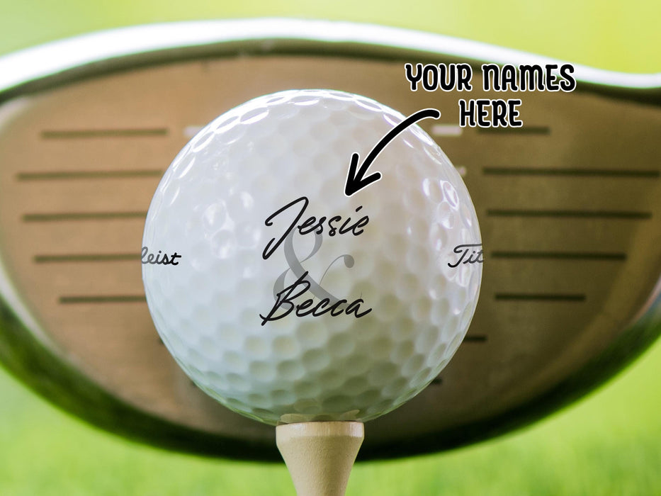 Titleist golf ball is shown sitting on a golf tee with a golf club behind it. Ball features custom printed Newlyweds&#39; Names Design. Text says: Your Names Here.