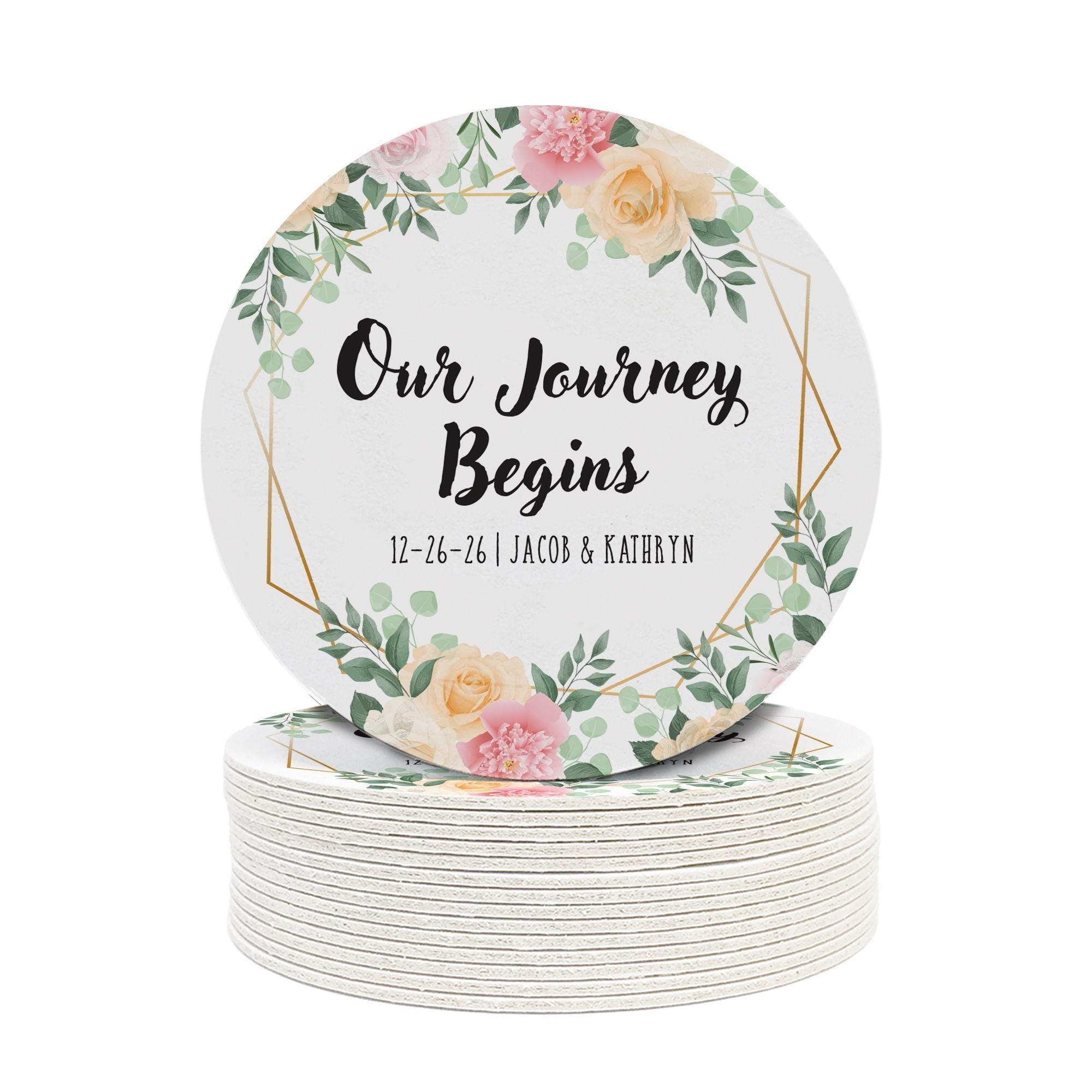 Personalized floral Save the Date coaster displayed beside a wine glass. Features a floral wedding design with custom details.