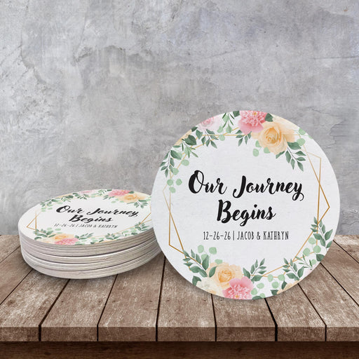 Floral Save the Date wedding coaster displayed on a rustic wood surface. Personalized with names and wedding date.