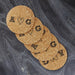 Set of personalized cork coasters with hand-drawn heart initials arranged on a dark background.