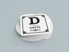 Stack of coasters sit on a gray background. Coasters say Davis with decorative frame.