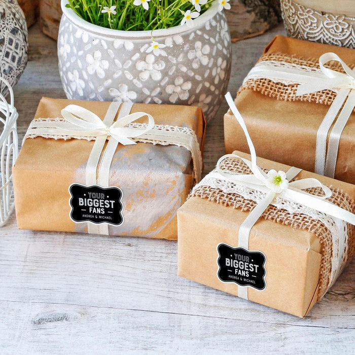 Wrapped wedding gifts tied with ribbon and decorated using personalized “Your Biggest Fans” foil wedding gift tags. Styled for weddings, bridal showers, and engagement celebrations.
