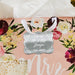 Romantic floral flat lay featuring a personalized “Mr. & Mrs.” wedding gift tag in metallic silver foil. Styled with flowers and soft wedding décor for bridal shower and wedding inspiration.