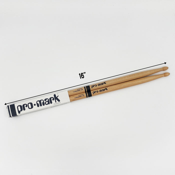 A pair of wooden drumsticks with the brand name "pro-mark" printed on them, lying on a white background.