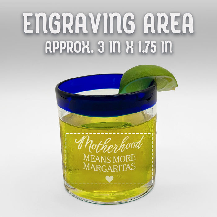 A glass with a blue rim and a lime wedge, along with the engraving of "motherhood means more margaritas" engraved on it. Engraving area is 3 inches x 1.75 inches.