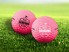 Two golf balls with the phrase "Best Grandma By Par" design printed on them, placed on a grassy field.