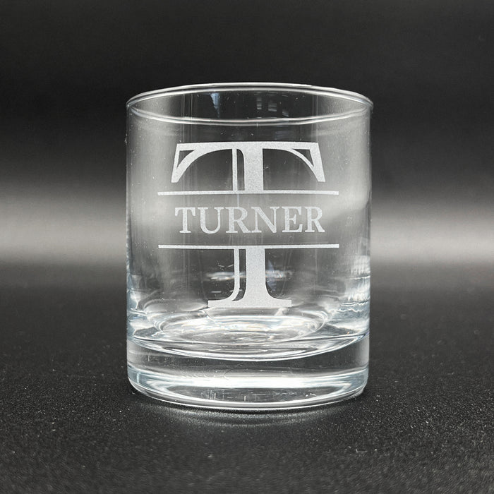 A clear glass with the name 'TURNER' engraved on it.