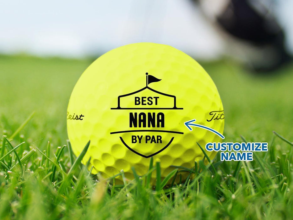 Custom yellow Titleist golf ball shown with a Best Nana By Par design printed on it. The golf ball sits on a grassy golf course.