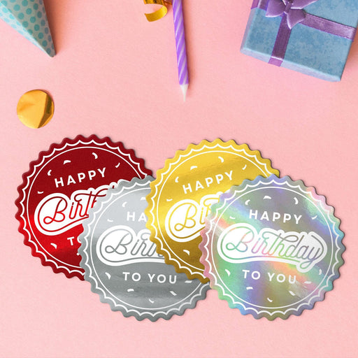 Four birthday round tags in metallic gold, metallic silver, glitter red, and glitter rainbow.