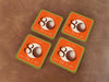 Custom square pulpboard coasters are shown sitting on leather surface. The coaster features design with illustrated golf ball, custom age and year, and vivid orange, cream, and green background.