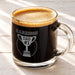 A glass mug filled with a dark liquid, likely coffee, with a foam top. The mug has a personalized message engraved on it, which reads "HARRISON DAD #1 2026".