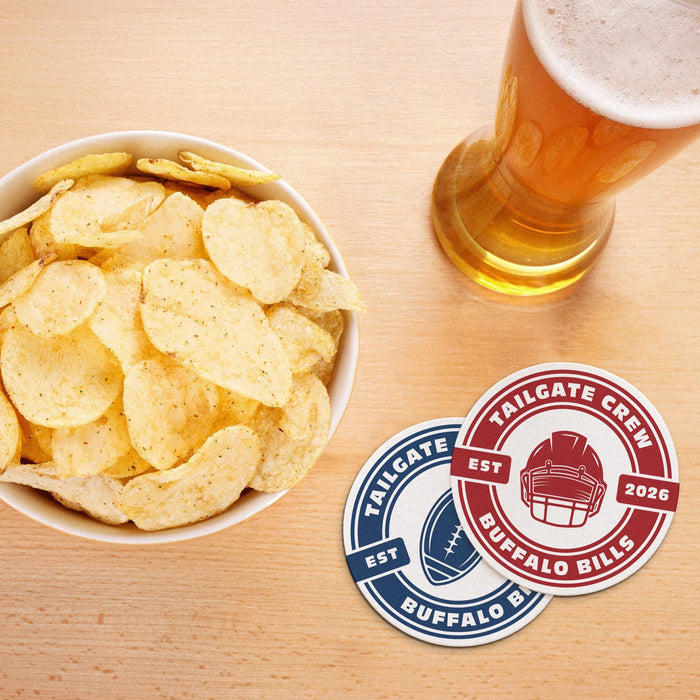 Red and blue team coasters displayed beside a bowl of chips and a glass of beer for a football watch party.