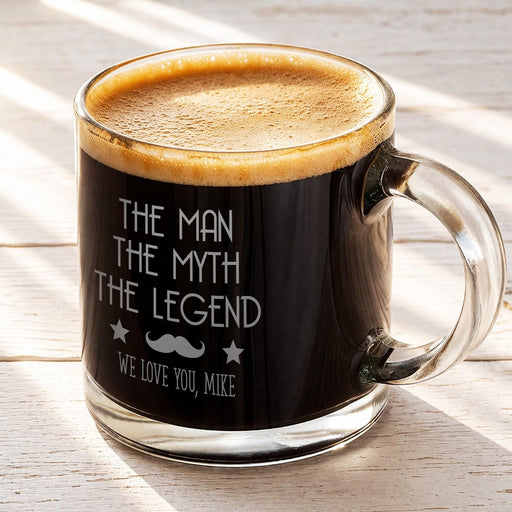 A mug with a black interior and a foamy top, filled with a dark liquid, and printed with text that reads "The man, the myth, the legend, we love you, Mike".