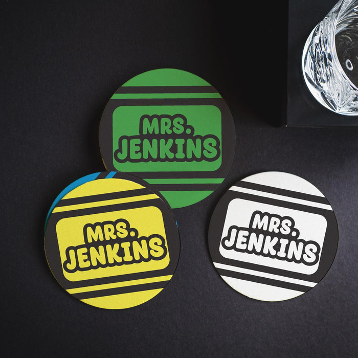 Multiple personalized Crayola coasters arranged on a dark background. Showcases color variation and visual contrast.