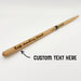 A wooden drumstick with the text "Keep marching forward" engraved on it, along with an arrow point toward it with the words "CUSTOM TEXT HERE" written next to it.