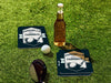 Custom square pulpboard coasters are shown sitting on a grassy, green golf course next to a bottle of beer, white golf ball, and golf club. The coaster features design with an illustration of a golf ball and with club behind it and custom text.