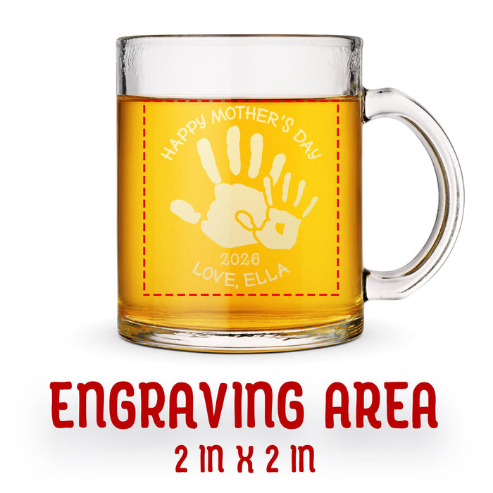 A glass mug with an engraved design on it. The mug is filled with tea, and there is text under the mug that reads "Engraving Area is 2 in x 2 in”
